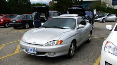 Silver coupe with aerodynamic front and classic headlight design