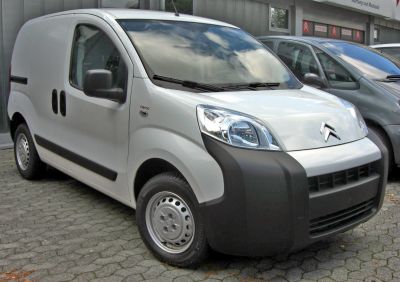 Compact white panel van with unique black front bumper and sliding side door