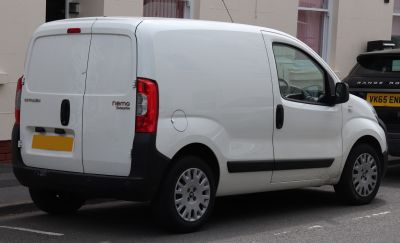 Rear side view of a white panel van with dual cargo doors and compact design