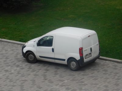 Compact white panel van with solid side panels and rear cargo doors