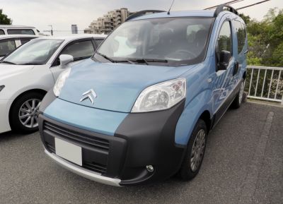 Front view of compact van with distinct headlights and protective black bumper