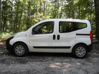 Compact white van side view with sliding doors and large windows