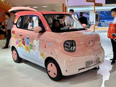 Compact pink electric vehicle with cartoon character decals and rounded headlights