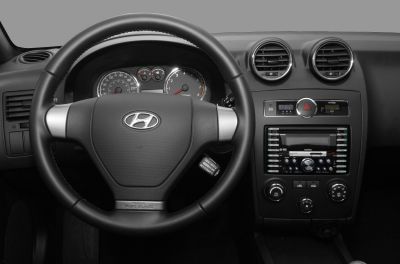 Steering wheel and dashboard with instrument panel and center console controls