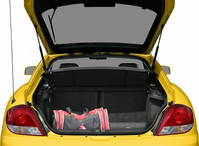 Open trunk with a sports bag inside of a yellow hatchback.