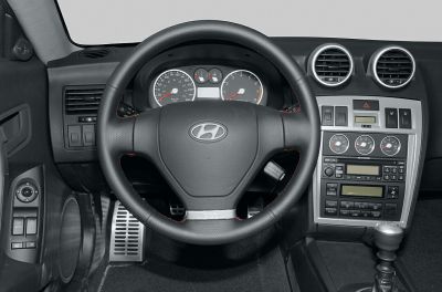 Steering wheel, instrument cluster, and center console with gauges and controls.