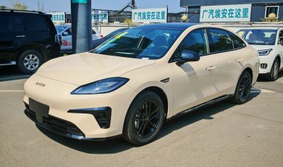 Front view of sleek electric sedan with modern headlights and black alloy wheels
