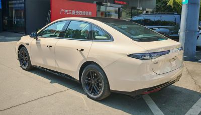 Rear-side view of sleek electric sedan with black wheels and modern taillights