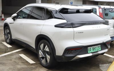 Rear and side view of a white modern electric SUV with aerodynamic design and sleek taillights.