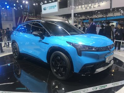 Blue electric SUV with black roof and aerodynamic headlights.