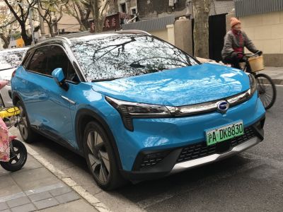Blue electric SUV with futuristic headlights and aerodynamic front design