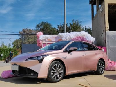Rose gold electric sedan with LED headlights and alloy wheels
