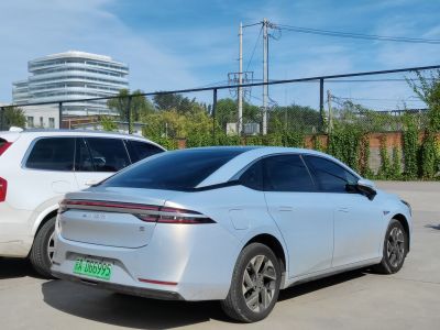 Rear and side view of electric sedan with continuous LED tail lights and flush door handles.