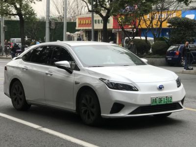 White sedan with sleek headlights and black wheels in urban street