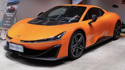 Orange sports coupe with carbon fiber hood and aerodynamic front details