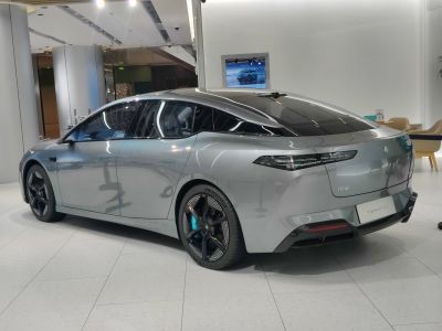 Sleek silver electric sedan rear and side view with aerodynamic design and black rims