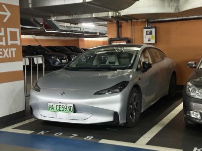 Sleek silver electric sedan with aerodynamic front and LED headlights
