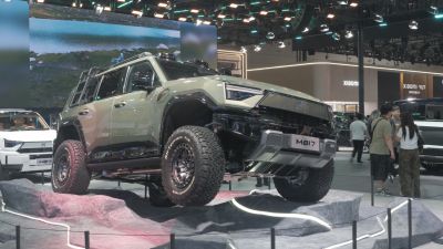 Rugged SUV with all-terrain tires on rocky display.