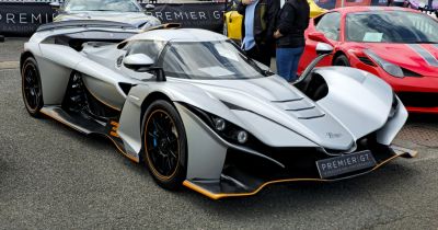 Aerodynamic hypercar front design with sharp side air intakes and carbon fiber details