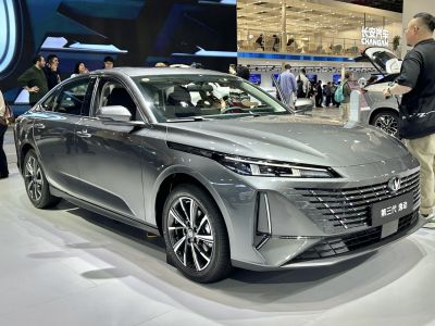 Front side view of a modern sedan with LED headlights and bold grille