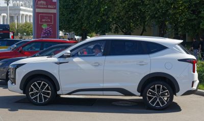 Side profile of white mid-size SUV with black accents and alloy wheels