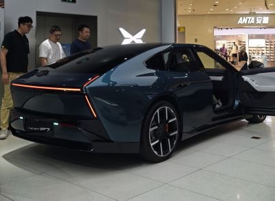 Rear view with continuous LED tail light and open driver's door.