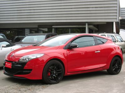 Red sporty coupe with sleek headlights and black rims