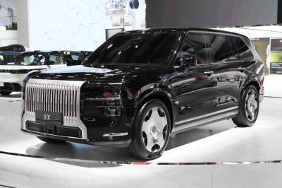 Glossy black luxury SUV with striking vertical grille and aerodynamic shape
