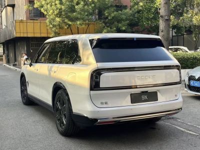 Rear view of a white electric SUV with tinted window and black rims