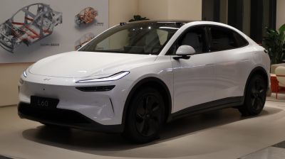 Sleek white electric SUV front and side view with modern headlights
