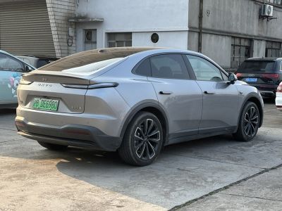 Electric sedan with coupe-like roofline, sleek rear lights, and alloy wheels