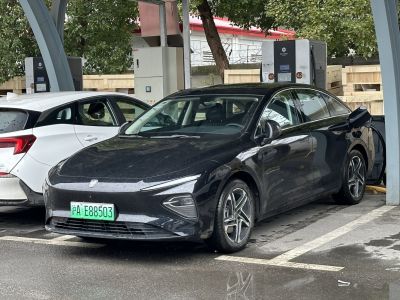 Black electric sedan at a charging station with modern design