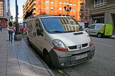 White panel van, front and side view, urban street parking