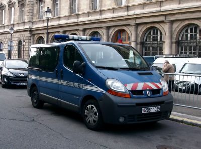 Blue police van with Gendarmerie markings and rooftop emergency lights