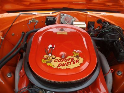 Engine air cleaner with Coyote Duster decal on a vintage muscle car engine.