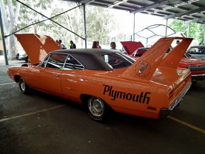 Tall rear wing and raised hood of a vintage muscle car