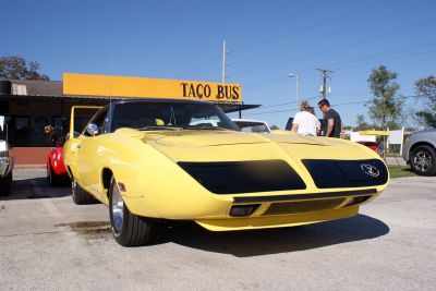 Aerodynamic pointed nose cone and masked headlights on yellow muscle car front