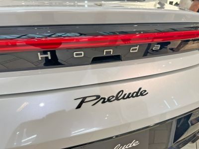 Rear badges and LED taillight strip of a modern white car