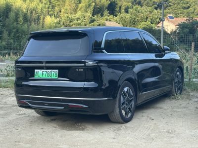 Rear and side view of a sleek luxury electric SUV with tinted windows