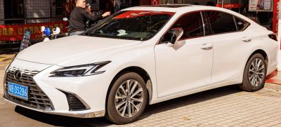 Front side view of white luxury sedan with LED headlights and alloy wheels