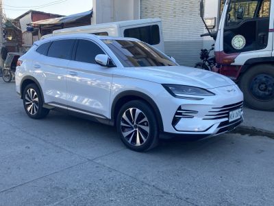 White SUV with sleek headlights and alloy wheels in front-side view