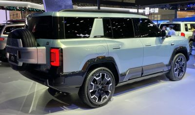 Rear-side SUV view with external spare tire and alloy wheels