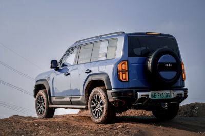 Rear and side view of a blue off-road SUV with spare tire mount and rugged styling