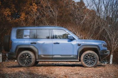 Rugged tires and boxy blue off-road SUV side profile