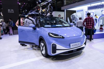 Compact electric vehicle with sleek headlights and roof-mounted bicycles