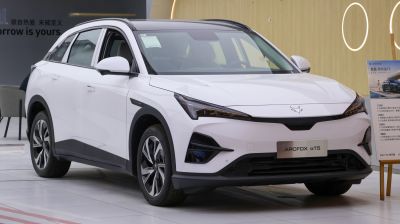 Front side view of a white modern electric SUV with aerodynamic design and advanced headlights