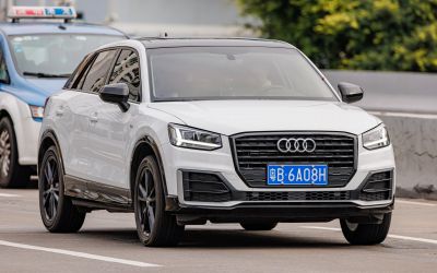 White compact SUV with black grille and black wheels driving on urban road