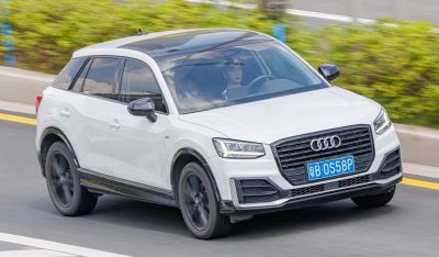White compact SUV with black roof and wheels in motion