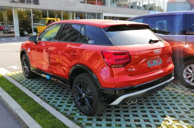Red compact SUV rear-side with dual exhaust and black wheels