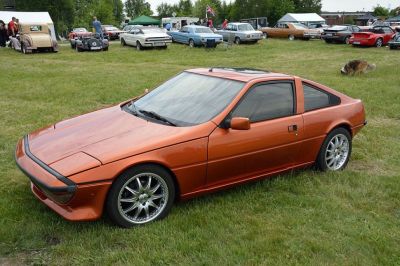 Angular sports coupe with pop-up headlights and alloy wheels in orange paint